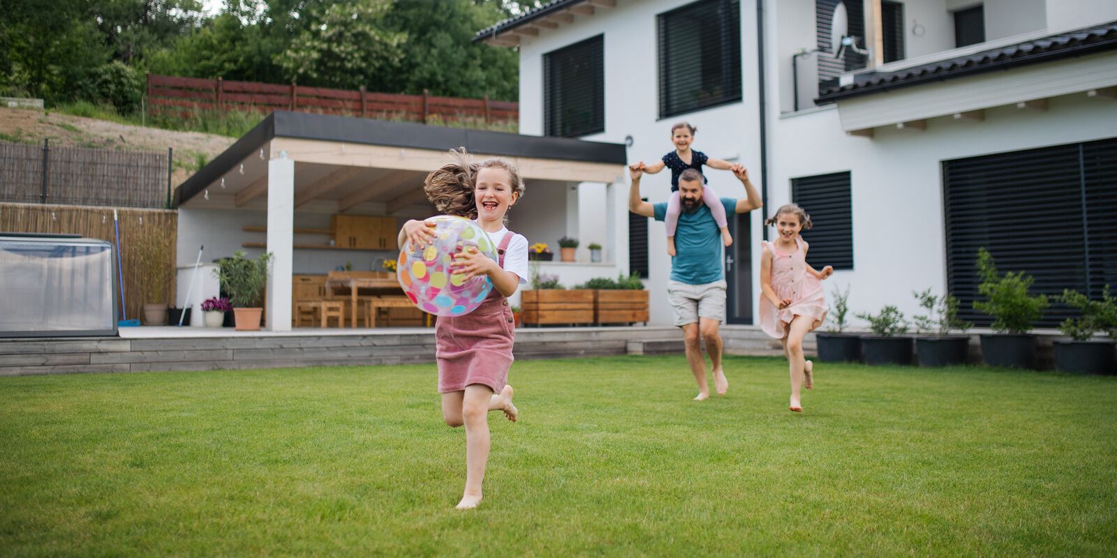 Familie spielt im Garten vor Ihrem Haus